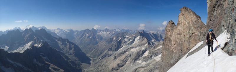 <p>Traversée du glacier Carré sous le Pic du Glacier Carré, avec le Grand Doigt à deux têtes et le vallon des Étançons au loin.</p>