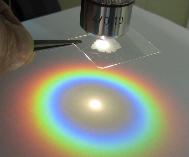 imulation expérimentale d’une gloire.
Diffraction de la lumière blanche par une simple couche de sphères de polystyrène de 1 micron de diamètre. On observe le phénomène en réflexion sur un écran, ce qui donne une véritable simulation expérimentale de la gloire. © Victor Canalejas Tejero, CSIC, Madrid, Spain. Source.